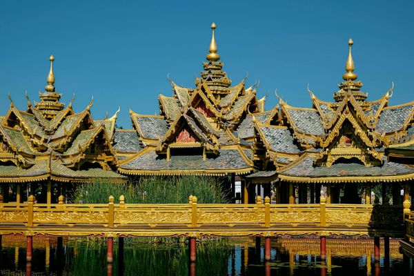 Majestic golden Buddhist temple gleaming under tropical sun in Bangkok