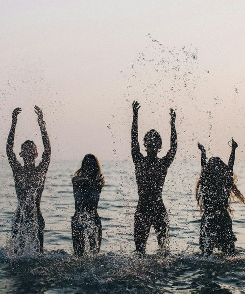 Young travelers enjoying sunset on tropical beach in Thailand